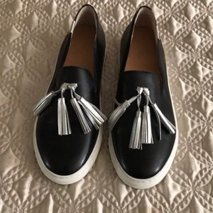Black loafers with silver tassels.